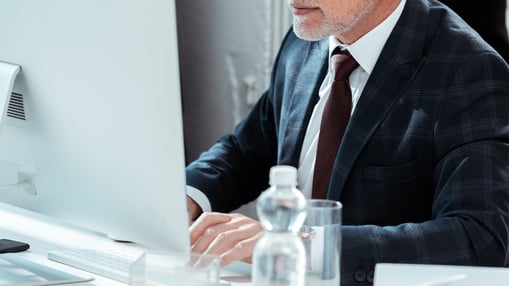 professional-looking CEO sitting at a desk with a computer doing Goal-setting