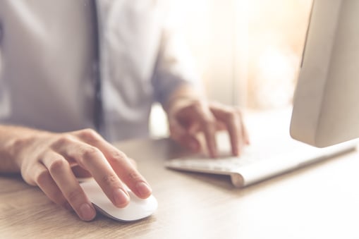 Person’s hand on computer selecting market research option